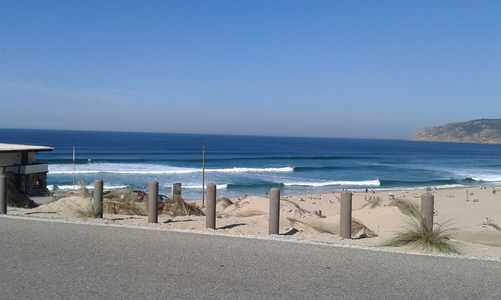 Praia do Guincho with clean lines of swell and the Sintra-Cascais headland in the distance